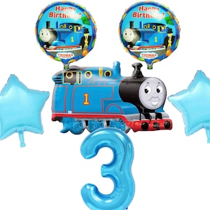 May include: A blue and red Thomas the Tank Engine train balloon with the number 1 on the side. There are two blue star balloons and two blue balloons with the words "Happy Birthday" and a picture of Thomas the Tank Engine on them. There is also a large blue number 3 balloon.