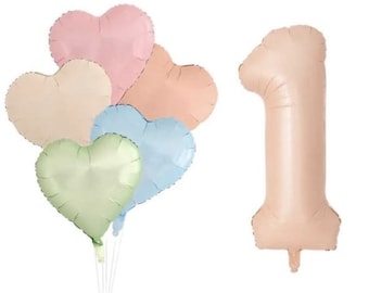 May include: A selection of heart-shaped balloons in pastel shades, including pink, peach, light blue, and green, next to a large number one balloon in a similar peach colour. The balloons are attached to white sticks.