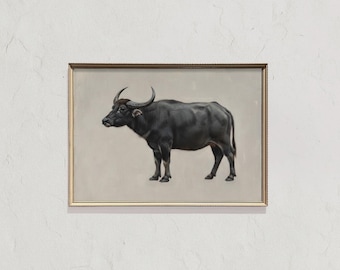 May include: A framed artwork featuring a black water buffalo. The buffalo is depicted in a realistic style, standing on a neutral background. The artwork is encased in a gold-colored frame, adding a touch of elegance to the piece.