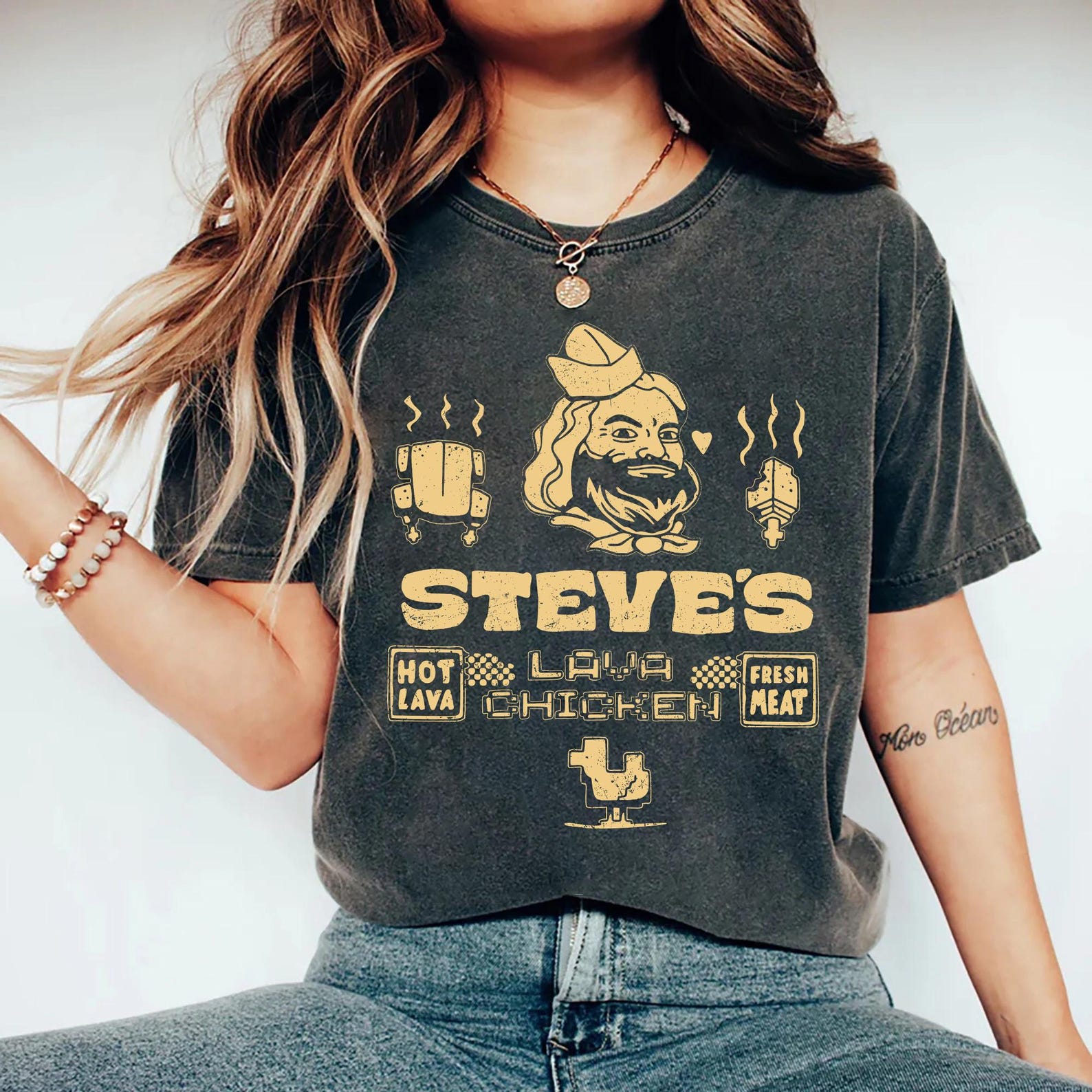A woman wearing a grey shirt with yellow text and graphics on it