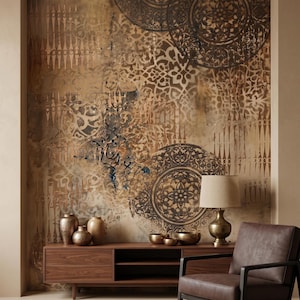 May include: An abstract wall mural with a distressed, textured design in shades of brown, beige, and bronze. The mural features circular and geometric patterns. A wooden cabinet with bronze vases and bowls sits below the mural, with a leather armchair and lamp.