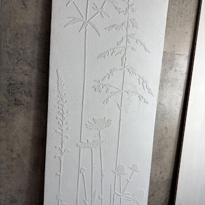 Peut inclure: Panneau rectangulaire blanc cass&eacute; avec un motif botanique en relief. L'&oelig;uvre pr&eacute;sente des repr&eacute;sentations d&eacute;taill&eacute;es de diverses plantes, notamment de longues tiges, des fleurs et du feuillage. Le relief cr&eacute;e une surface textur&eacute;e, am&eacute;liorant la profondeur visuelle.