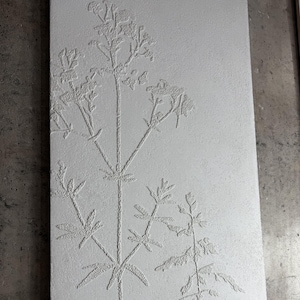 Peut inclure: Panneau rectangulaire blanc cass&eacute; avec un relief botanique en relief. Le motif pr&eacute;sente une tige centrale avec des tiges ramifi&eacute;es et des feuilles d&eacute;taill&eacute;es, cr&eacute;ant une esth&eacute;tique textur&eacute;e et naturelle. La surface du panneau a une texture subtile et granuleuse.