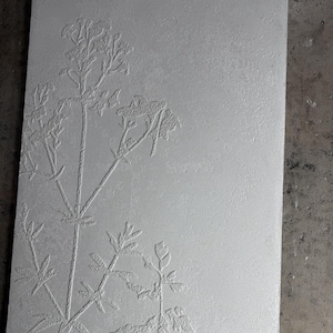 Peut inclure: Panneau rectangulaire gris clair avec un motif floral en relief. Le motif botanique en relief pr&eacute;sente des tiges, des feuilles et de d&eacute;licates grappes de fleurs. La surface textur&eacute;e ajoute de la profondeur et de l'int&eacute;r&ecirc;t visuel &agrave; l'&oelig;uvre.