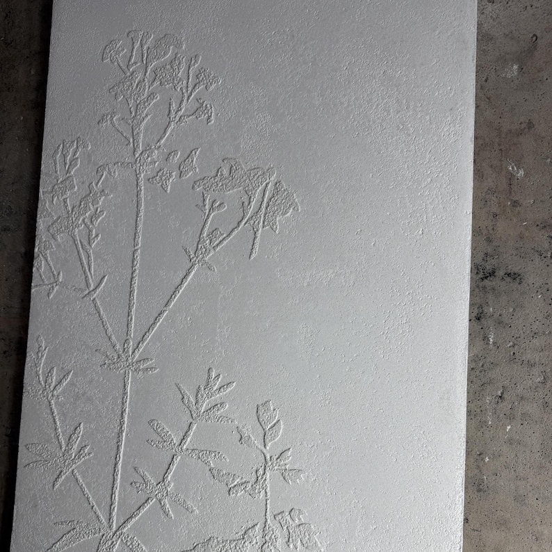 Peut inclure: Panneau rectangulaire gris clair avec un motif floral en relief. Le motif botanique en relief pr&eacute;sente des tiges, des feuilles et de d&eacute;licates grappes de fleurs. La surface textur&eacute;e ajoute de la profondeur et de l'int&eacute;r&ecirc;t visuel &agrave; l'&oelig;uvre.