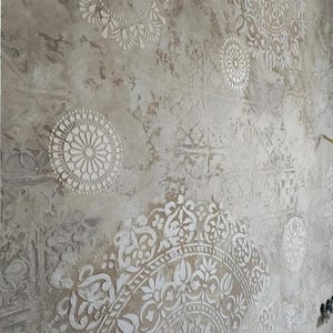 May include: Textured wall with a distressed, aged appearance. The wall features a neutral color palette with white, raised, circular and floral patterns. The design creates a vintage, artistic aesthetic, suitable for interior decor.