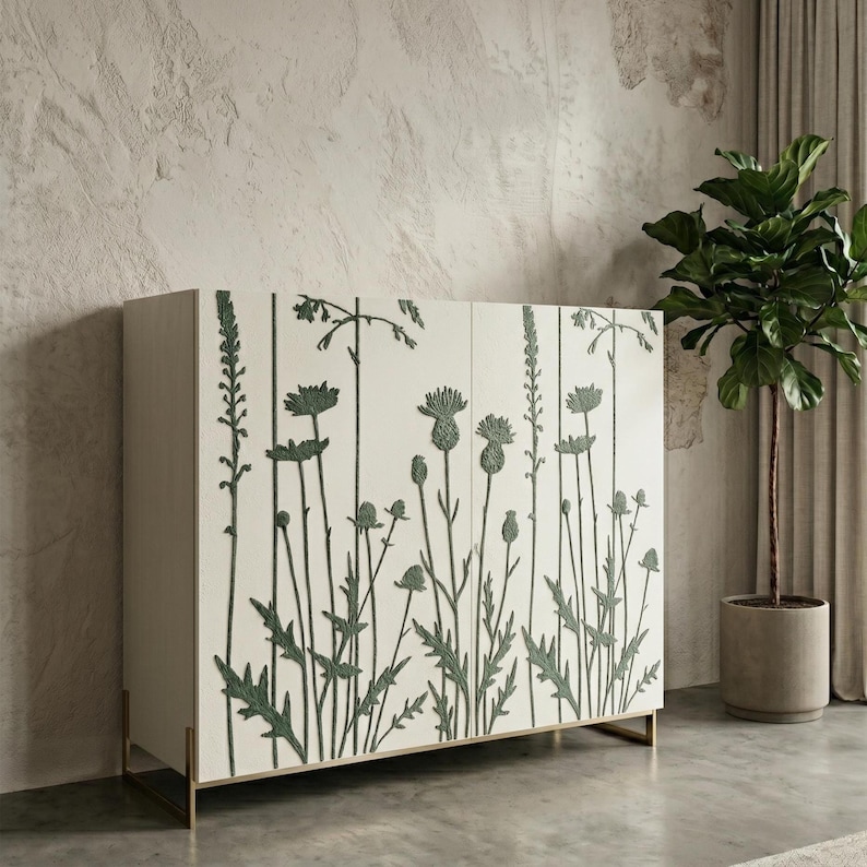 Peut inclure: Un buffet blanc avec des motifs floraux verts. Le meuble a une forme rectangulaire et des pieds dor&eacute;s. Le motif floral comprend diverses plantes et fleurs. Le buffet est plac&eacute; devant un mur textur&eacute;.