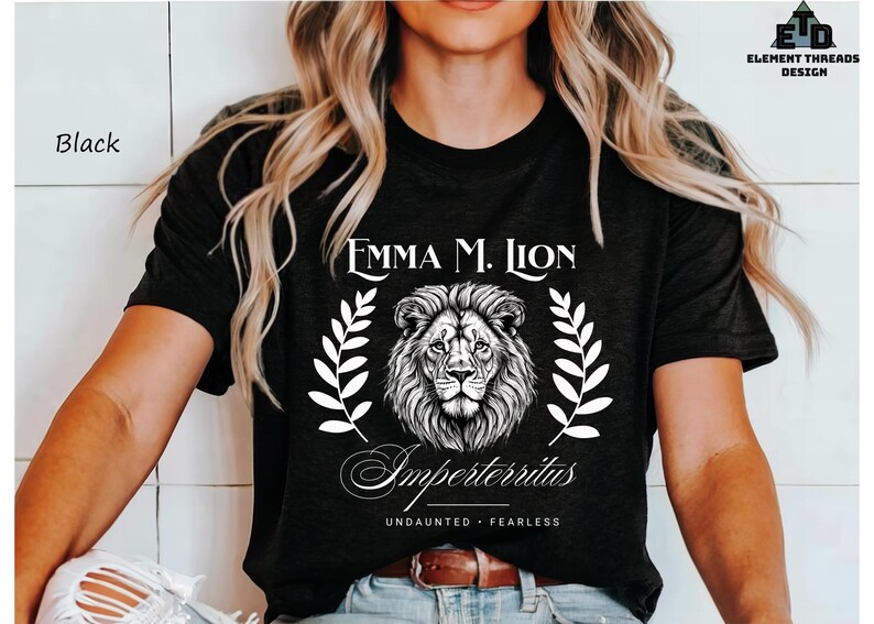 A woman wearing a black t-shirt with a lion graphic and text printed on it.