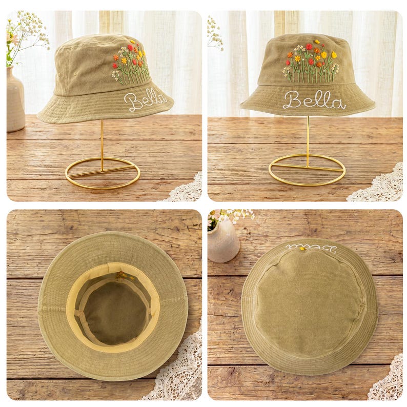 May include: A tan bucket hat featuring embroidered colorful wildflowers and the name Bella stitched in white cursive thread. The hat has a wide brim and a structured crown, shown from multiple angles including the interior and top view.