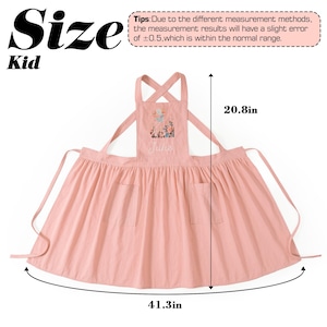 May include: A light pink child's apron featuring a floral embroidery and the name Jule on the chest. The apron has two front pockets and crisscross straps. Dimensions are 20.8 inches in height and 41.3 inches in width as indicated by arrows.