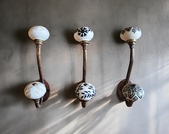 May include: Three decorative wall hooks with ceramic knobs. Each knob features a different black and white floral design.