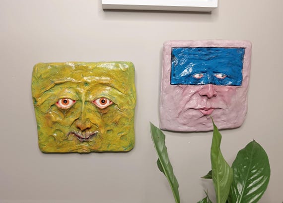Handmade hanging face sculptures that toe the line between unsettling and oddly lovable — the kind of wall art guests will stop and stare at.