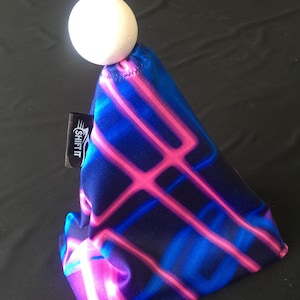 Puede incluir: Una funda de palanca de cambios con estampado negro, azul y rosa con una bola blanca en la parte superior. La funda tiene la palabra "SHIFT" impresa en el lateral.