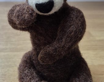 Hand made, needle felted brown bear on a log