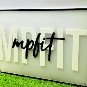 May include: White sign with black frame and black lettering that reads "mpfit".