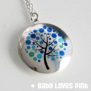 Puede incluir: Collar con dije de plata con un diseño de árbol azul y verde. El árbol está hecho de pequeños círculos.