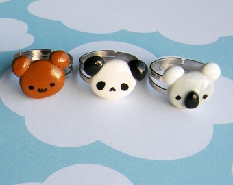 May include: Three adjustable rings with cute animal faces. The rings feature a brown bear, a black and white panda, and a gray koala.