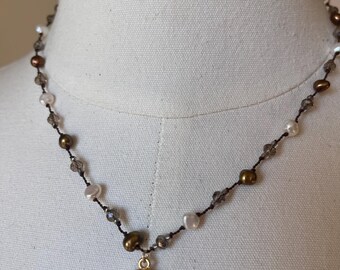 Mabe coin pearl and gold plated setting with chocolate pearls freshwater pearls and smoky crystals. 18 inches in length. Very classic.