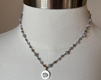 Hill tribe fine silver pendant in a lotus blossom design with cream, topaz, light, blue, and dark blue crystals