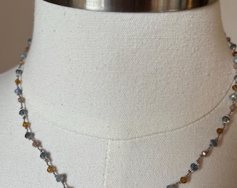 Floater necklace, 17 inches long with blues and topaz crystals on a gray polymer and nylon filament. Very durable. Neutral and pretty