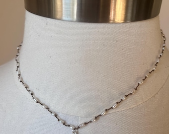 Tiny little freshwater, pearl and nodded on a polymer nylon filament that is waterproof. 15 inches in length. Sterling silver flower pendan