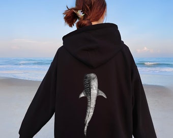 May include: Black hoodie with a white whale shark graphic on the back. The hoodie has a drawstring hood and a kangaroo pocket.