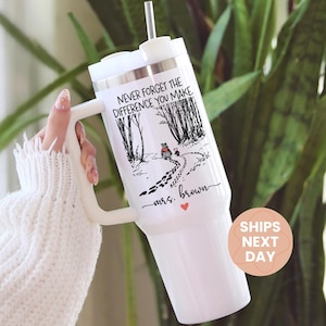 May include: White insulated tumbler with a handle and a straw. The tumbler features a black and white graphic with the text "NEVER FORGET THE DIFFERENCE YOU MAKE" and "mrs. Brown" with a red heart.