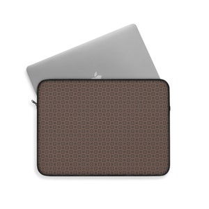 May include: A brown laptop sleeve with a repeating geometric pattern of circles and squares. The sleeve is open, with a silver laptop partially inserted. The sleeve has a black zipper and trim.