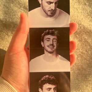 Puede incluir: Tres fotos en blanco y negro de un hombre con cabello oscuro y barba. El hombre lleva una camiseta blanca en cada foto. En la primera foto, el hombre mira hacia abajo. En la segunda foto, el hombre sonr&iacute;e y mira a la c&aacute;mara. En la tercera foto, el hombre mira hacia un lado.