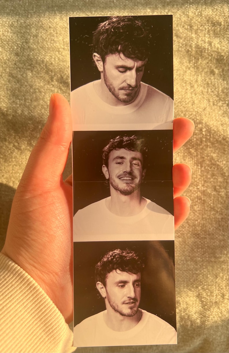 Puede incluir: Tres fotos en blanco y negro de un hombre con cabello oscuro y barba. El hombre lleva una camiseta blanca en cada foto. En la primera foto, el hombre mira hacia abajo. En la segunda foto, el hombre sonr&iacute;e y mira a la c&aacute;mara. En la tercera foto, el hombre mira hacia un lado.