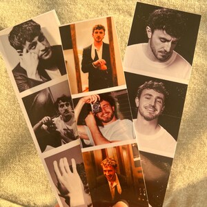 Puede incluir: Una colecci&oacute;n de fotos estilo Polaroid con un hombre joven en varias poses. Las fotos est&aacute;n dispuestas en una pila vertical, con la foto superior mostrando al hombre mirando hacia abajo, la segunda foto mostr&aacute;ndolo mirando a la c&aacute;mara, la tercera foto mostr&aacute;ndolo sosteniendo una c&aacute;mara, la cuarta foto mostr&aacute;ndolo sonriendo y la quinta foto mostr&aacute;ndolo mirando a la c&aacute;mara.