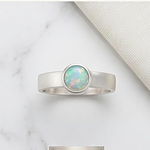 Ring i sterlingsilver med vit eldopal, rund bezel och statement-smycken