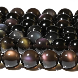 May include: A strand of iridescent black gemstone beads. The beads are round and have a smooth, polished finish. The beads are strung on a clear thread.