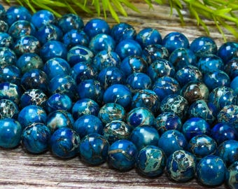 Könnte beinhalten: Eine Strähne aus blauen und weißen marmorierten runden Perlen. Die Perlen haben einen Durchmesser von etwa 8 mm und eine glatte, polierte Oberfläche.