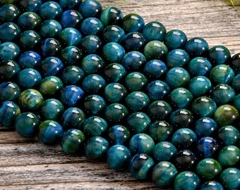 Puede incluir: Una hebra de cuentas redondas de ojo de tigre azul y verde. Las cuentas tienen un acabado liso y pulido y un patrón natural estriado.