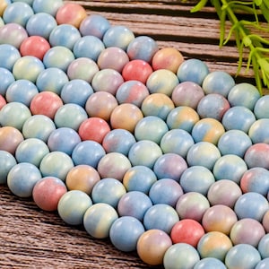 May include: A strand of pastel-colored ceramic beads. The beads are round and have a marbled effect with shades of blue, pink, yellow, and white.
