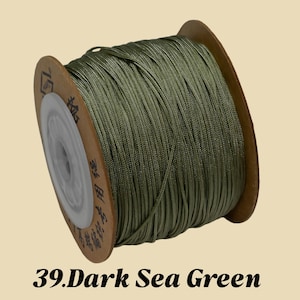 Puede incluir: Un carrete de cord&oacute;n verde mar oscuro. El cord&oacute;n est&aacute; bien enrollado en un carrete de cart&oacute;n con un n&uacute;cleo de pl&aacute;stico blanco. El texto "39. Dark Sea Green" est&aacute; en la parte inferior de la imagen.
