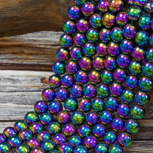 May include: A strand of iridescent hematite beads in shades of purple, green, and blue. The beads are round and have a smooth, polished finish.