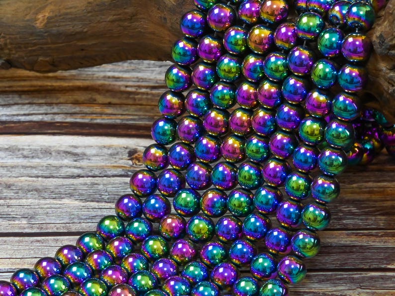 May include: A strand of iridescent hematite beads in shades of purple, green, and blue. The beads are round and have a smooth, polished finish.