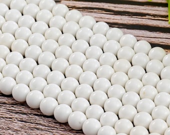 Puede incluir: Una hebra de cuentas redondas blancas, hechas de materiales naturales, para la elaboración de joyas.