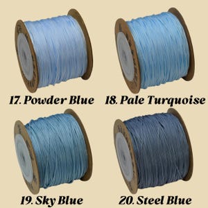 Puede incluir: Cuatro carretes de cord&oacute;n azul, cada uno enrollado en una bobina de cart&oacute;n. Los colores son Azul Polvo, Turquesa P&aacute;lido, Azul Cielo y Azul Acero. El texto en la imagen indica los nombres y n&uacute;meros de los colores.