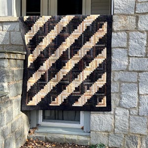 Puede incluir: Una taza de cerámica blanca con un asa negra y el texto "But First, Coffee" en un estilo manuscrito. La taza está sobre una superficie blanca. La taza mide aproximadamente 10 cm de alto.