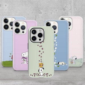 Può includere: Cinque custodie per telefono con disegni a cartoni animati di Snoopy in tonalità pastello di blu, rosa e verde. Ogni custodia presenta un'illustrazione diversa di Snoopy, come Snoopy con fiori o che dorme. Le custodie sono progettate per uno smartphone.