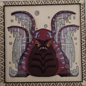 May include: A square wooden art piece featuring a stylized creature with a maroon body, blue accents, and a detailed face. The background has a light color with a geometric design. The artwork is framed with a decorative border.