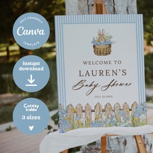 May include: A baby shower sign with a blue and white striped border. The sign reads "Welcome to Lauren's Baby Shower" with the date July 22 20XX. A bunny in a basket of flowers is at the top.