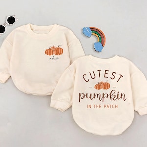 May include: Two cream colored long-sleeved shirts with pumpkin designs. One shirt says "Cutest pumpkin in the patch" and the other says "andrew" with three pumpkins.