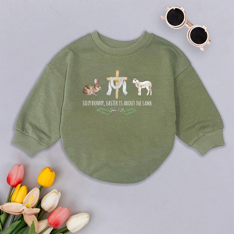May include: Green long-sleeved sweatshirt with a graphic of a bunny, a cross, a lamb, and the text "Silly Bunny, Easter is about the Lamb, John 1:29".