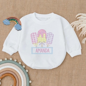 May include: White long-sleeved sweatshirt with a graphic of three colorful popsicles and the name "AMANDA" printed below.