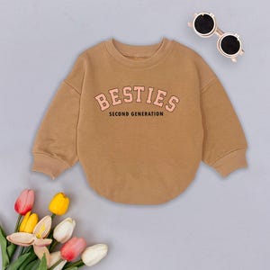 May include: A brown sweatshirt with a pink graphic that says "BESTIES SECOND GENERATION".