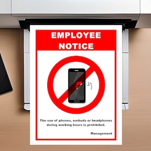 May include: A red and white sign with a red circle and a diagonal line through it. The circle contains a black smartphone with a white earbud next to it. The sign reads "EMPLOYEE NOTICE" and "The use of phones, earbuds or headphones during working hours is prohibited. Management."